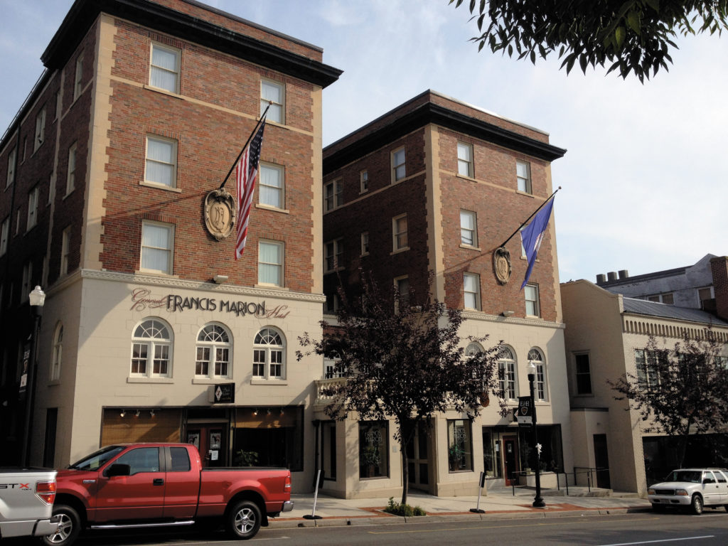 The General Francis Marion Hotel sits in downtown Marion. The upper floors have a red brick façade and the flags of the U.S. and the commonwealth of Virginia wave from the building's exterior.