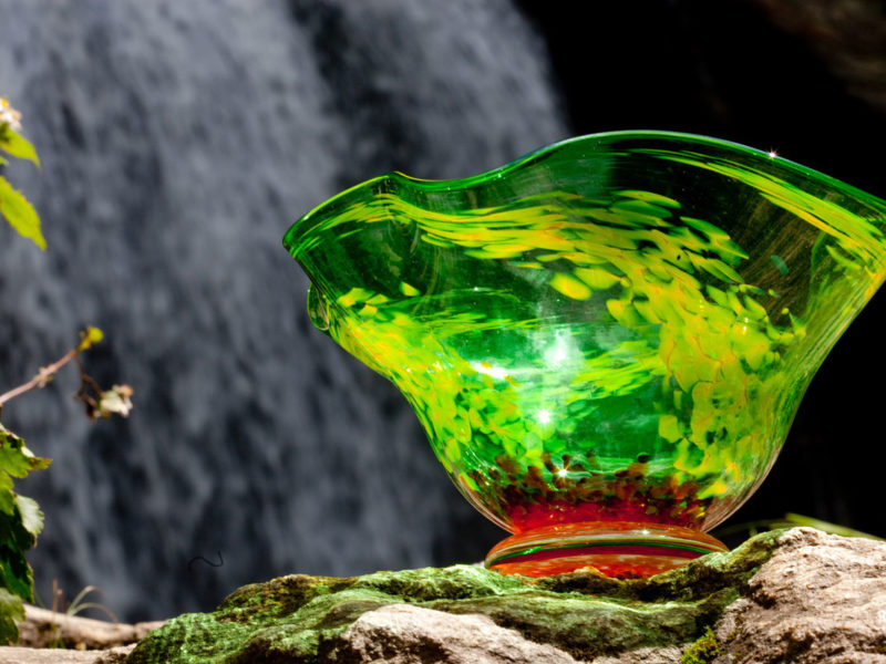 A brightly colored green glass bowl reflects light.