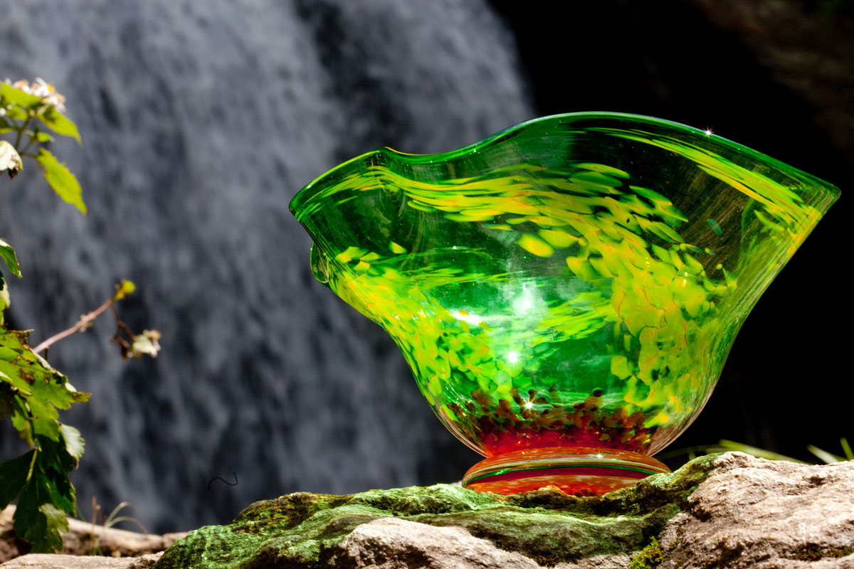 A brightly colored green glass bowl reflects light.