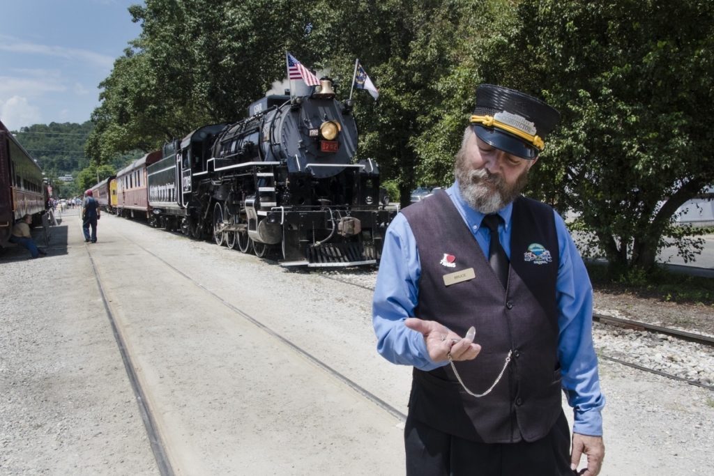 A train conductor checks his watch at the Great Smoky Mountains Railroad in Bryson City, North Carolina
