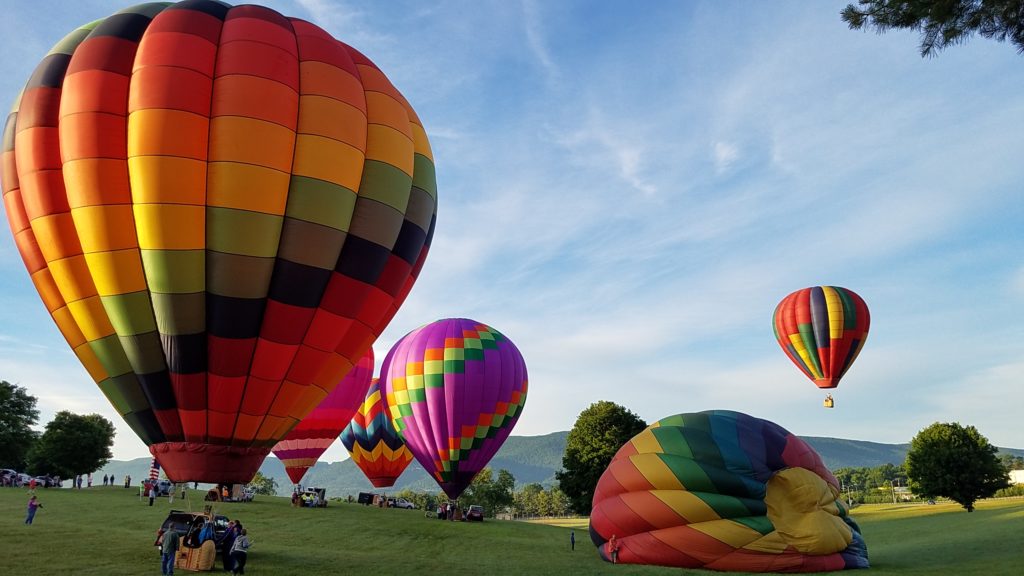 Many multi-colored hot air balloons are preparing to rise from a field in Wytheville.