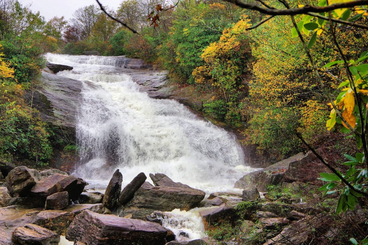 Water rushes over Second Falls at Graveyard Fields with hints of fall color on the trees.