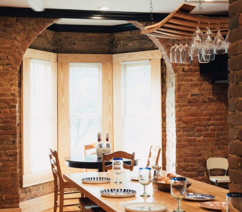 Large windows overlooking a dining table at Roanoke Boutique Hotel