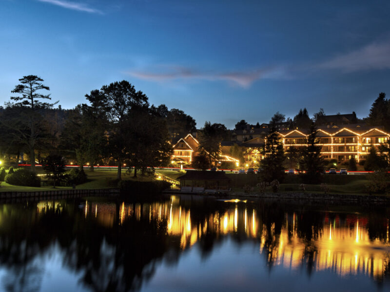 Night time view of Chetola Resort lights reflecting on the lake.