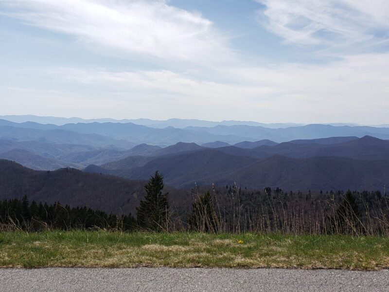 The view from an overlook at the southern end of the Parkway reveals row upon row of bluish mountains under a hazy sky.