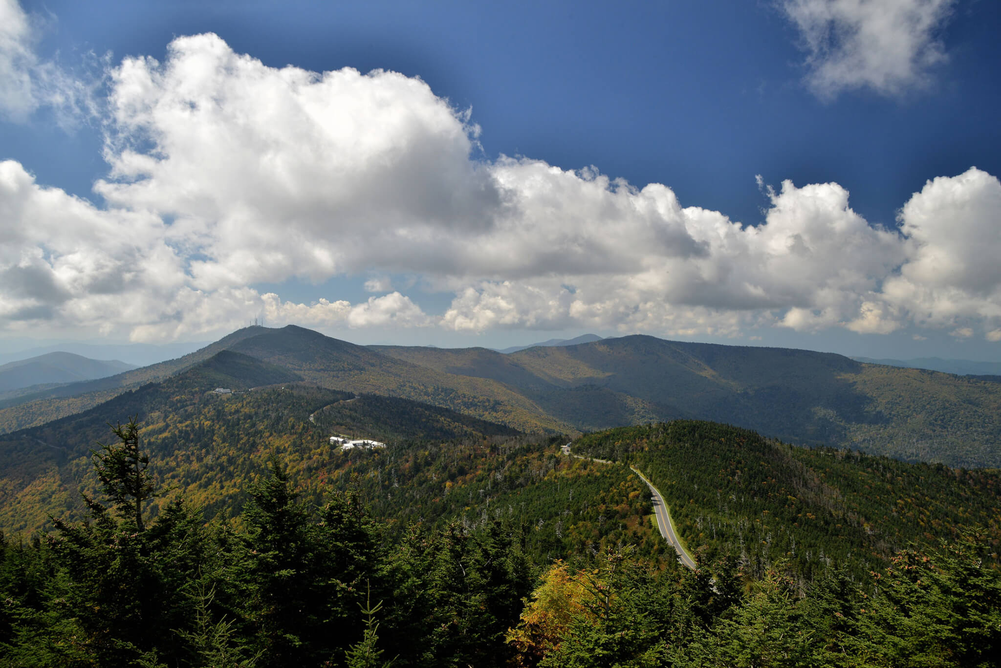 a section of the blue ridge parkway winds through forested mountains on a cloudy day