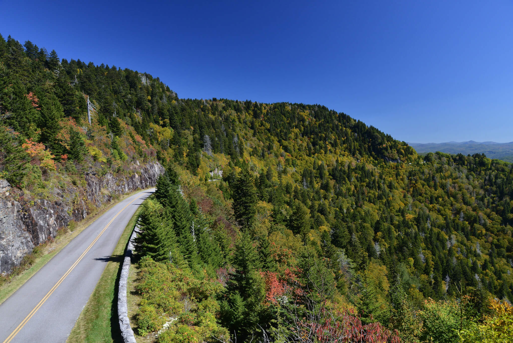 a paved road cuts through the mountains of the blue ridge parkway